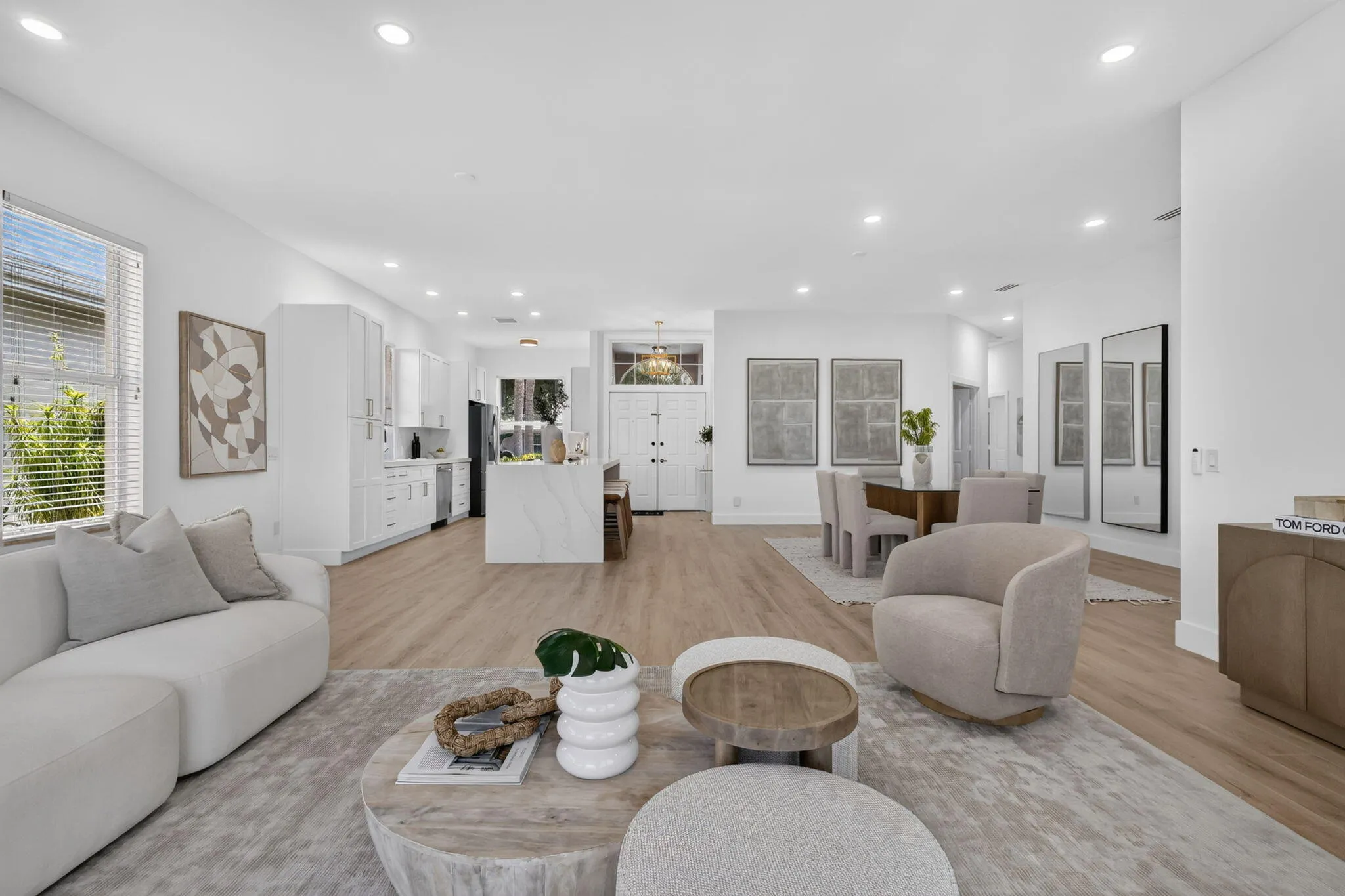 Open-concept living area featuring wood-finish flooring, recessed lighting, and a kitchen island with a waterfall edge