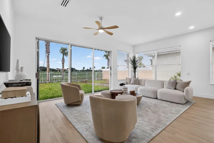 Bright interior with wood-finish flooring, recessed lighting, ceiling fan, and sliding glass doors