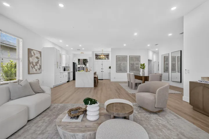 Open-concept living area featuring wood-finish flooring, recessed lighting, and a kitchen island with a waterfall edge