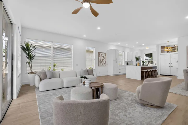 Expansive open-concept living area featuring wood-finish flooring, recessed lighting, and a ceiling fan