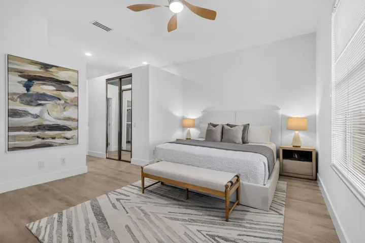Vaulted ceiling with a ceiling fan, wood-finish flooring, recessed lighting, and sliding mirrored closet doors