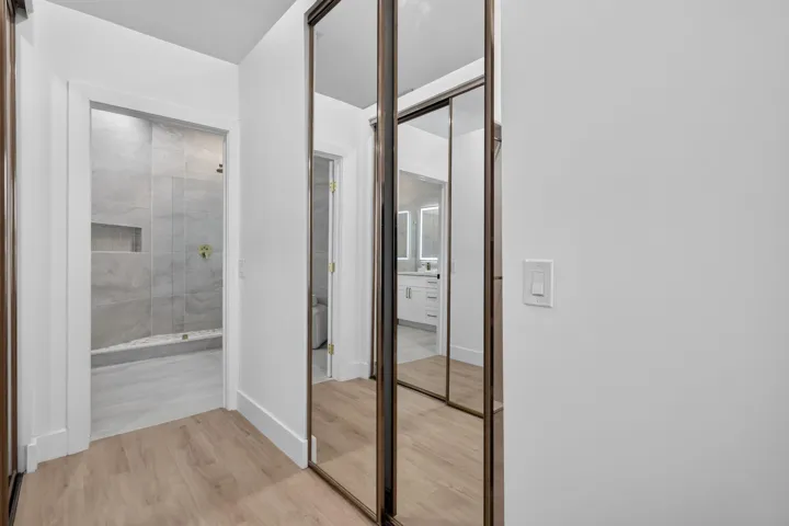 Wood-finish flooring, mirrored sliding closet doors, and recessed lighting