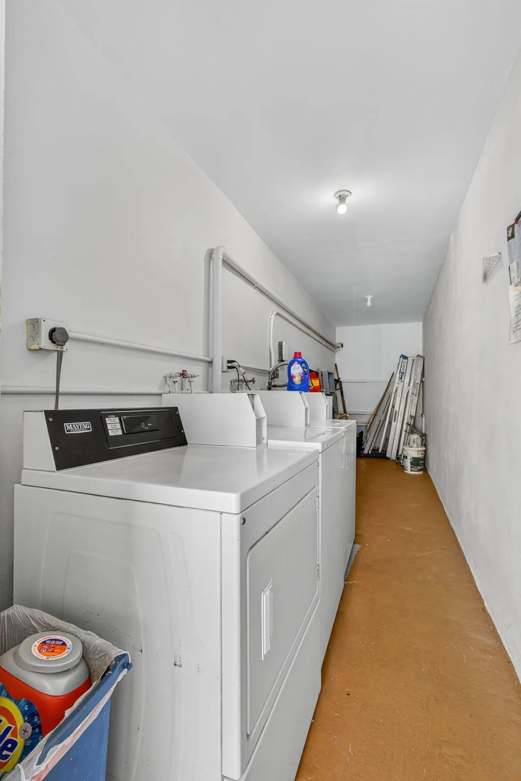 White painted walls with flush-mount lighting, and commercial-grade laundry machines
