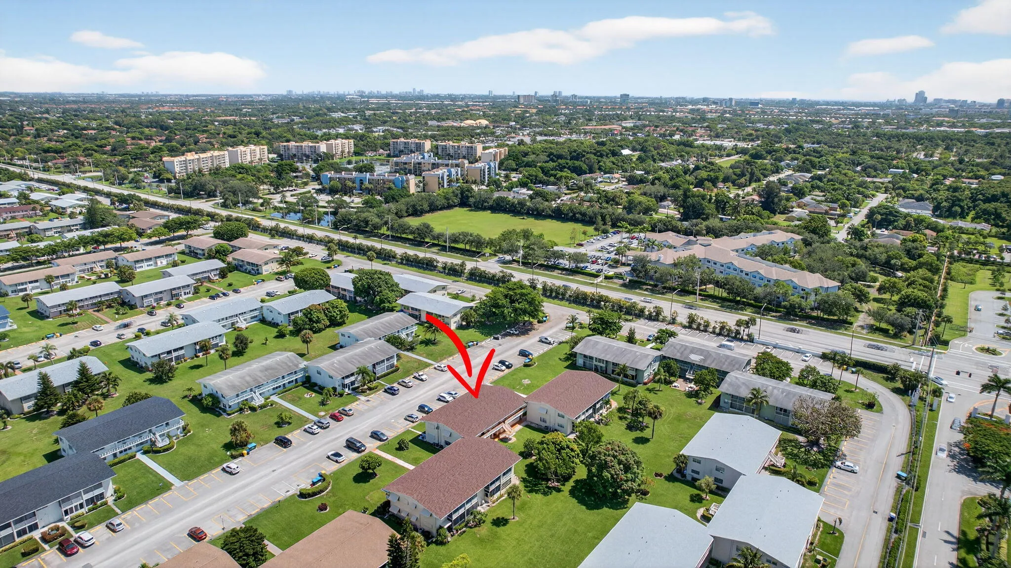 Expansive neighborhood with multiple residential buildings, surrounded by green spaces and mature trees