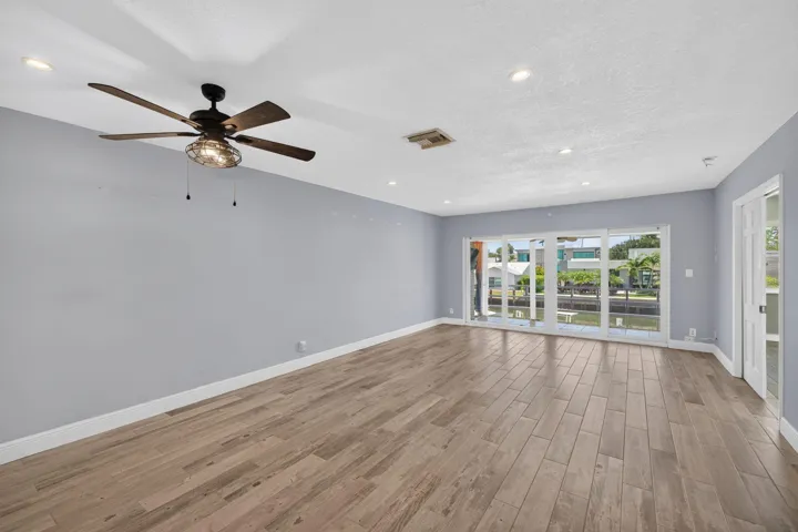 Wood-finish flooring, recessed lighting, and a ceiling fan with integrated lighting