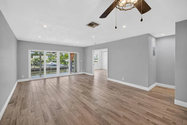 Wood-finish flooring throughout, recessed lighting, and a ceiling fan with integrated light