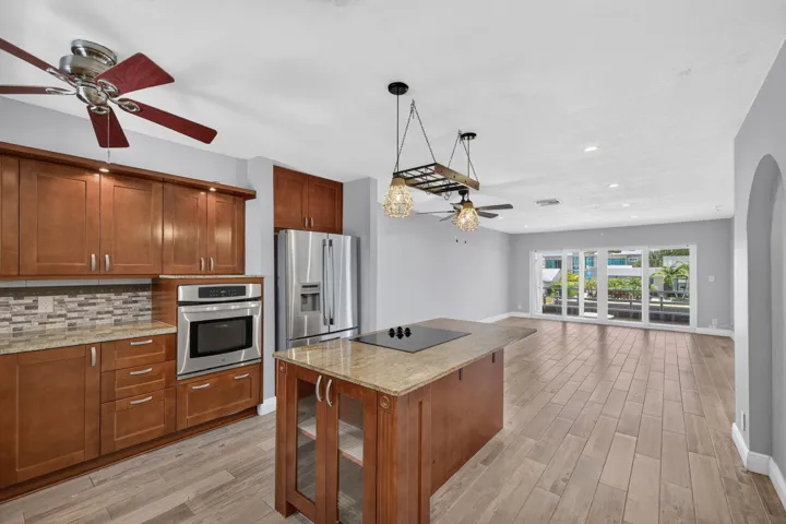 Kitchen with wood-finish cabinetry, stainless steel appliances, and a mosaic tile backsplash