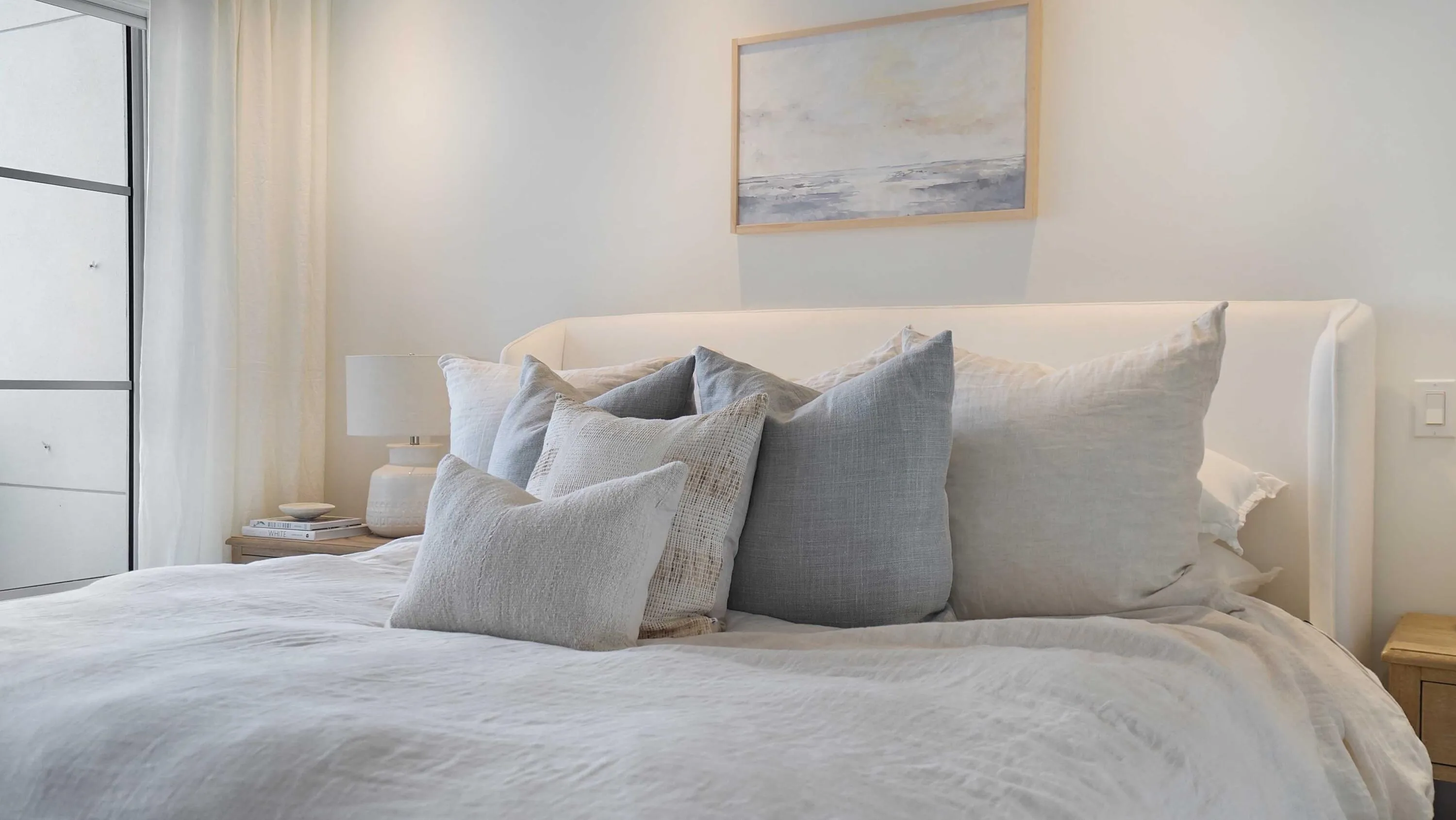 The primary suite continues the residence’s considered palette, with layered window treatments and private outdoor access.
