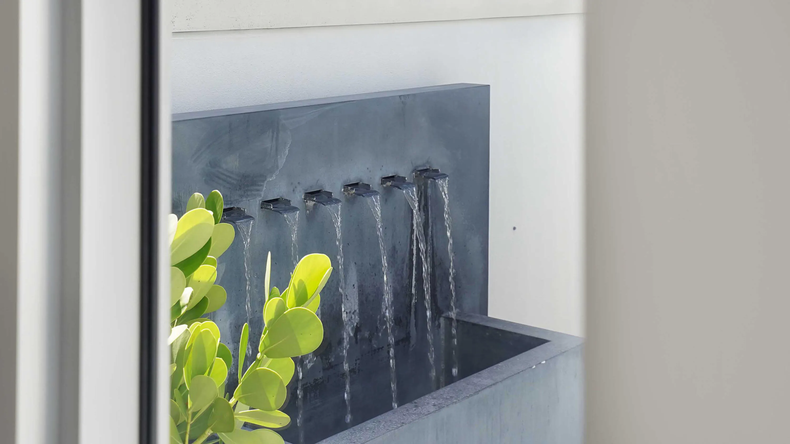 An integrated water feature introduces texture and movement to the outdoor setting.