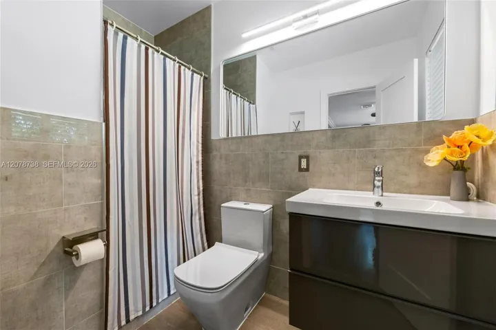 The bathroom continues the home’s contemporary feel with streamlined finishes, a floating vanity, and a neutral palette.