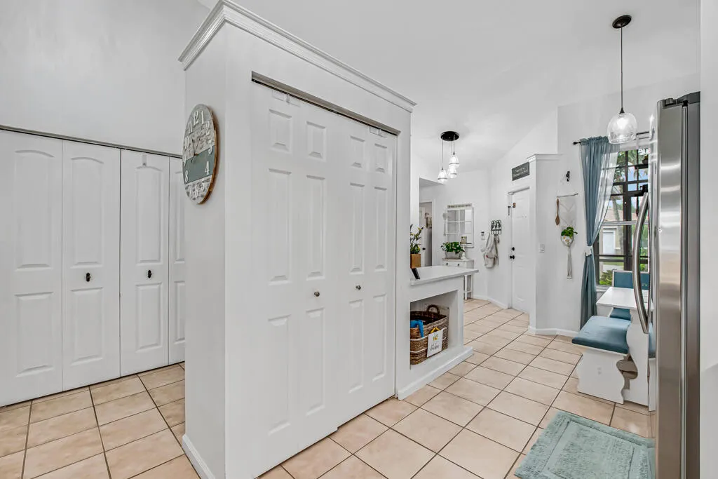 Vaulted ceilings, tile flooring, built-in storage shelving, pendant lighting, and stainless steel appliances