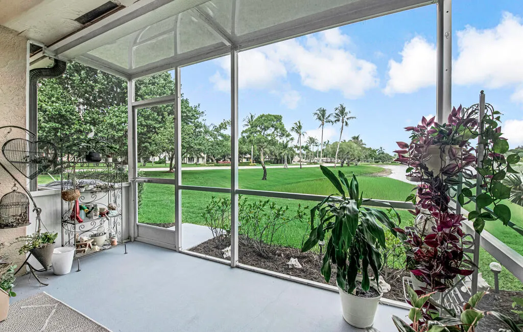 Screened outdoor living area with a painted concrete floor, white aluminum framing, and a screened door