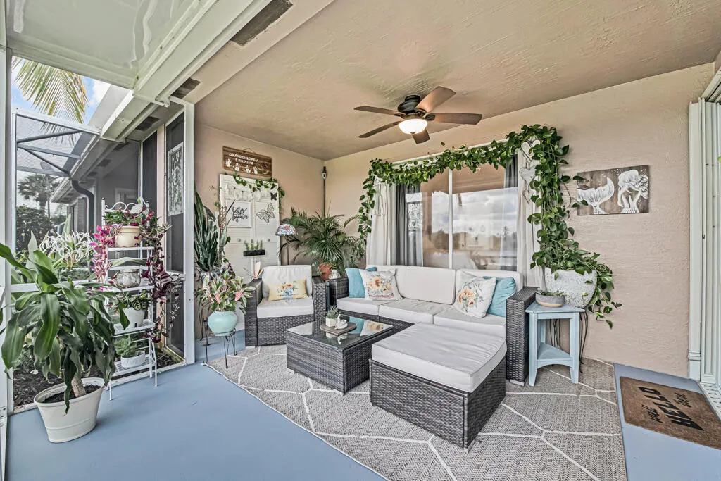 Screened-in patio with a textured ceiling, a ceiling fan, and sliding glass doors