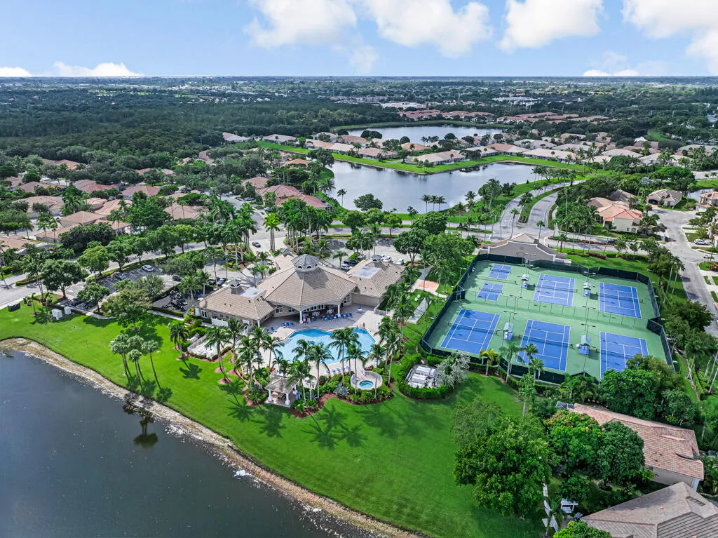 Community amenities featuring a central clubhouse, swimming pool, tennis courts, and surrounding residential properties
