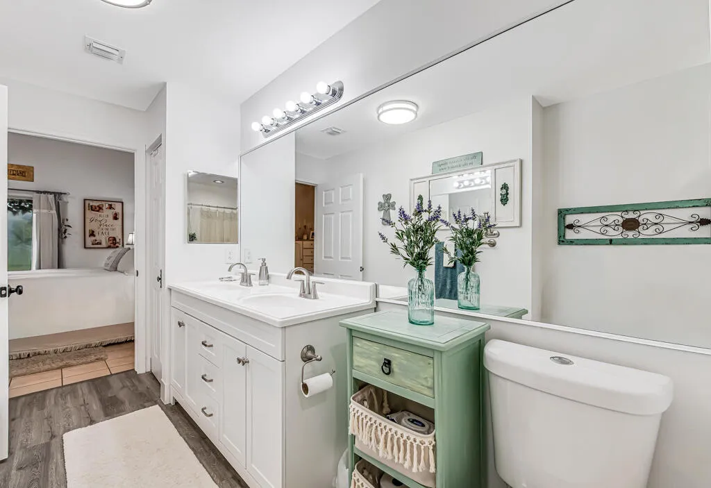 Dual vanity with undermount sinks, chrome fixtures, and white cabinetry