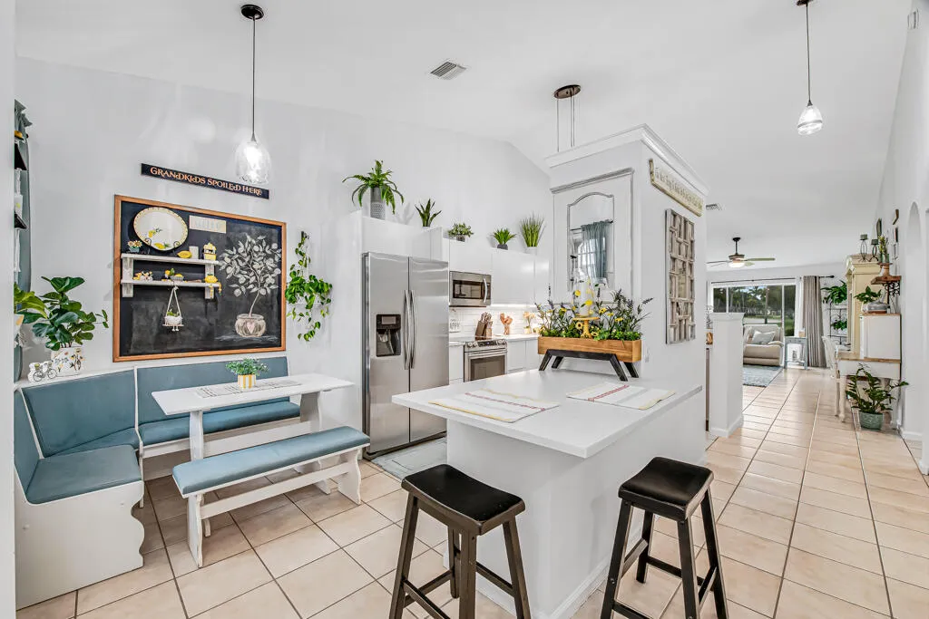 Kitchen featuring stainless steel appliances, white cabinetry, and a breakfast bar with seating