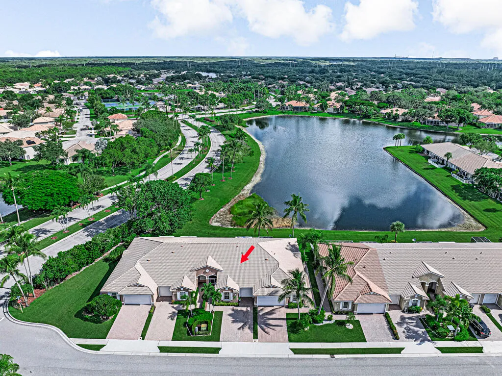 Aerial perspective of a multi-unit property with a barrel tile roof, paver driveways, and manicured landscaping