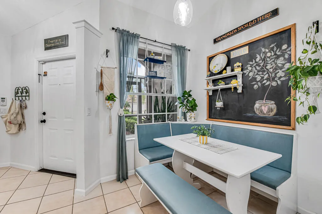 White interior walls with a built-in banquette, a large window, and tile flooring