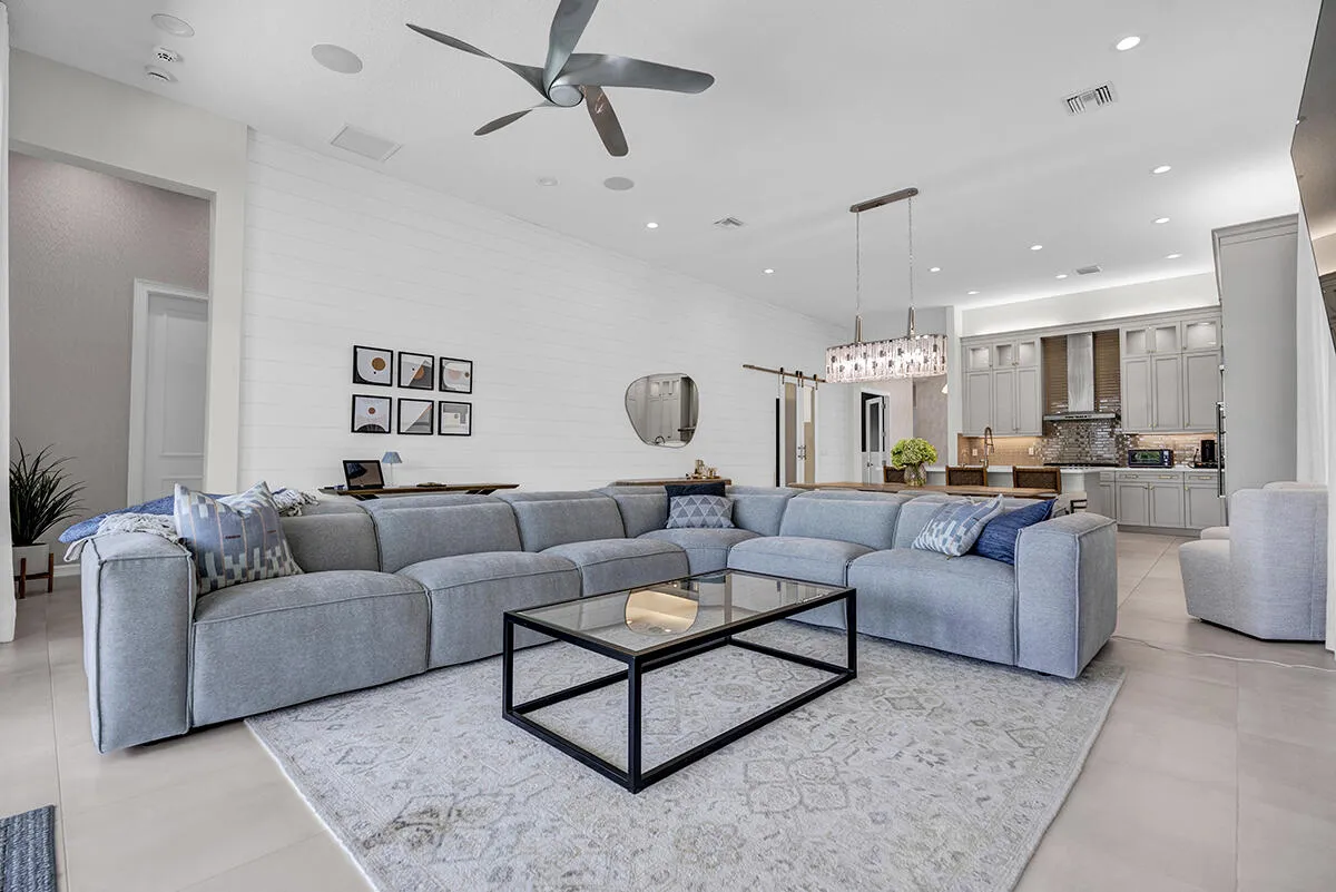 Spacious open-concept living area featuring high vaulted ceilings, recessed lighting, and a contemporary ceiling fan