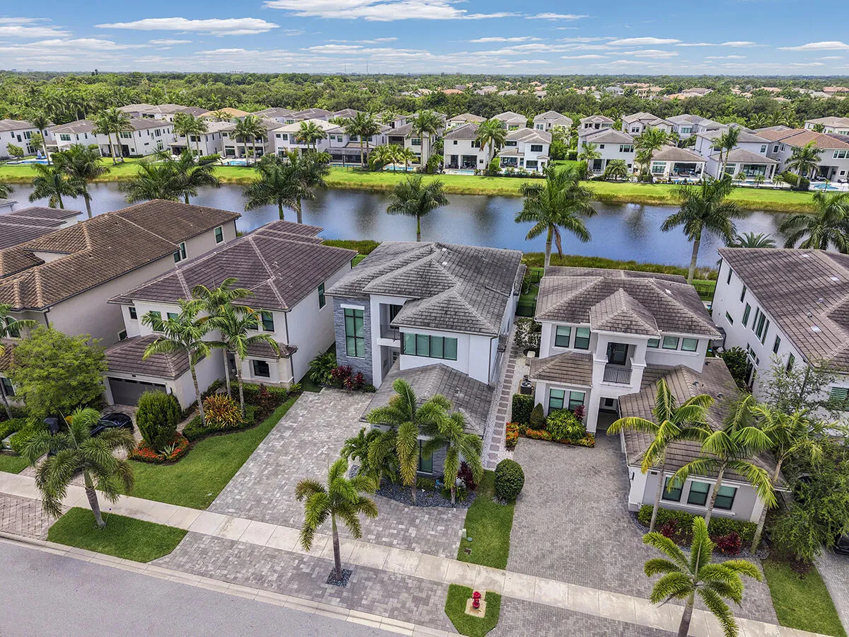 Two-story residence featuring a tile roof, a paver driveway, and an integrated two-car garage