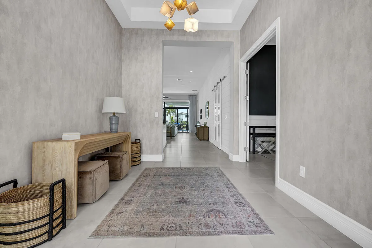 Spacious entry foyer featuring light-toned walls, tile flooring, and a contemporary ceiling fixture
