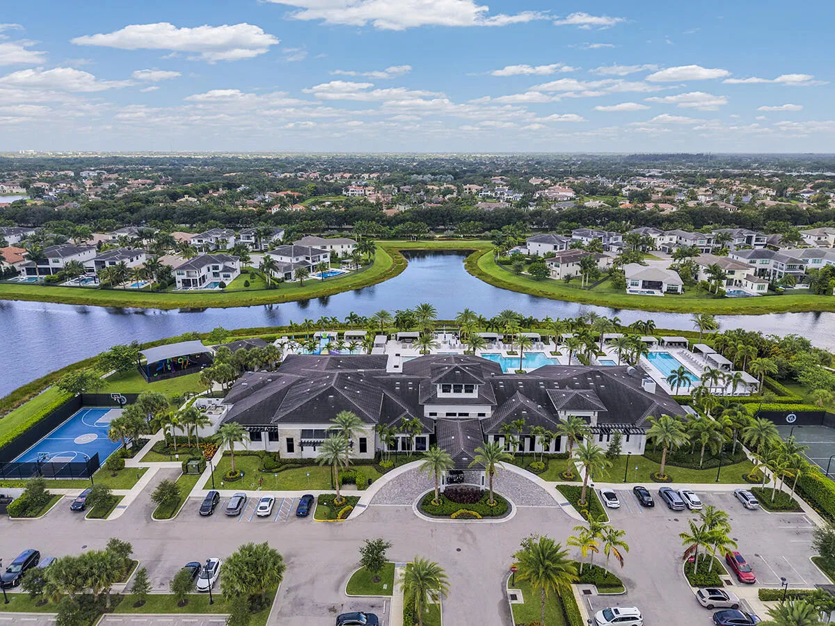 Expansive community clubhouse featuring a large swimming pool, outdoor lounging areas, a basketball court, and tennis courts