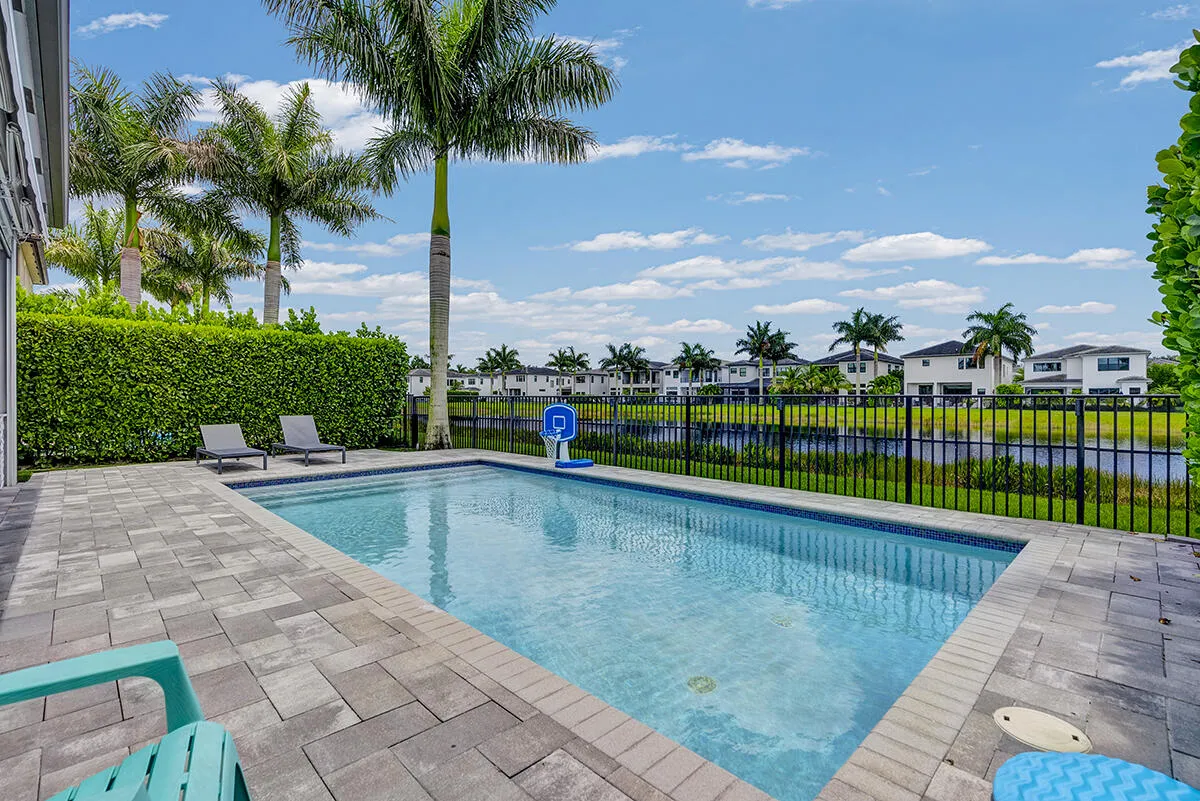Rectangular swimming pool surrounded by paver patio