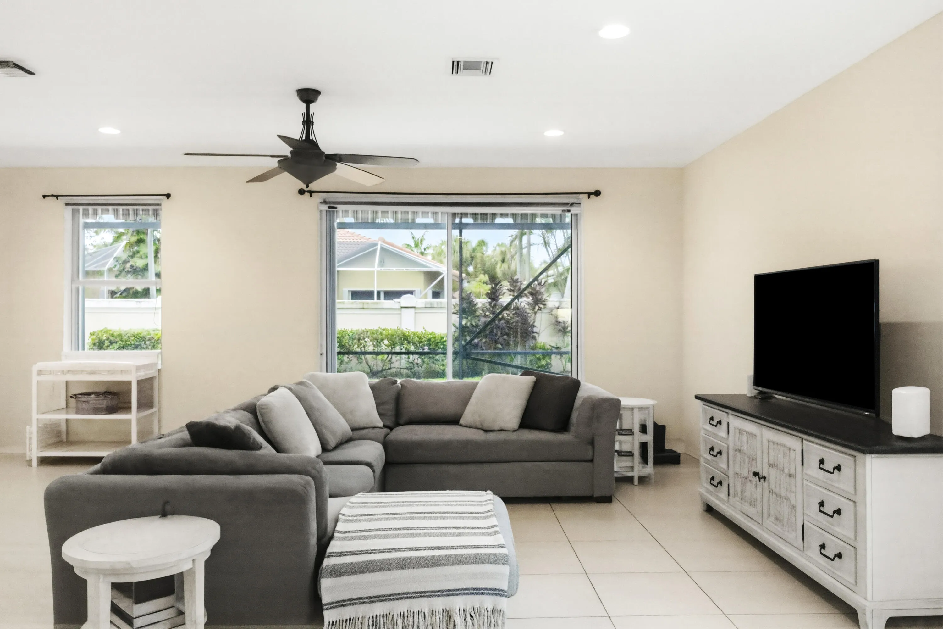 Recessed lighting, ceiling fan, tile flooring, sliding glass door, and large window