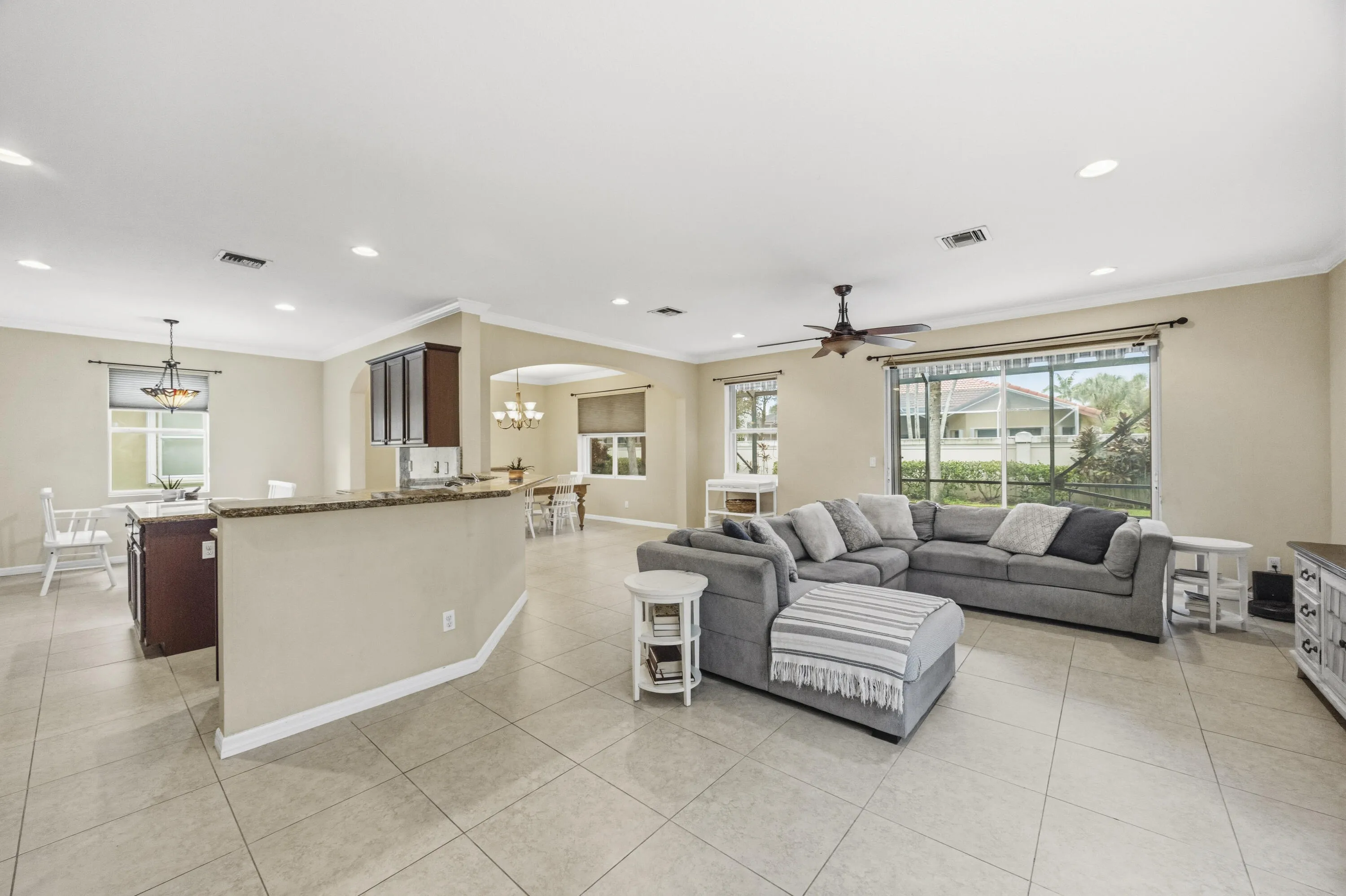 Open-concept living area with tiled flooring, recessed lighting, and a ceiling fan