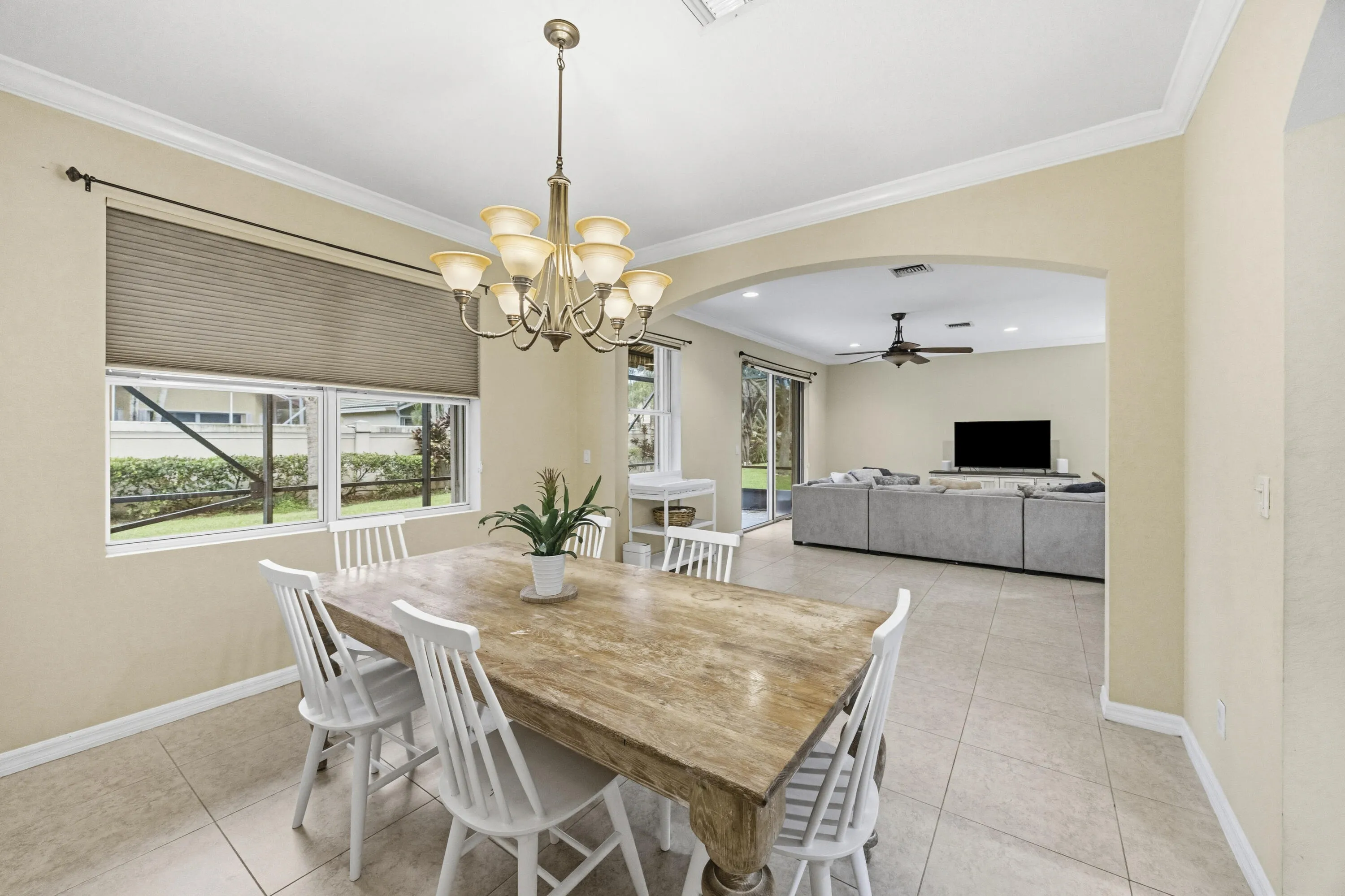 Recessed lighting, crown molding, arched entryway, tile flooring, and a ceiling fan