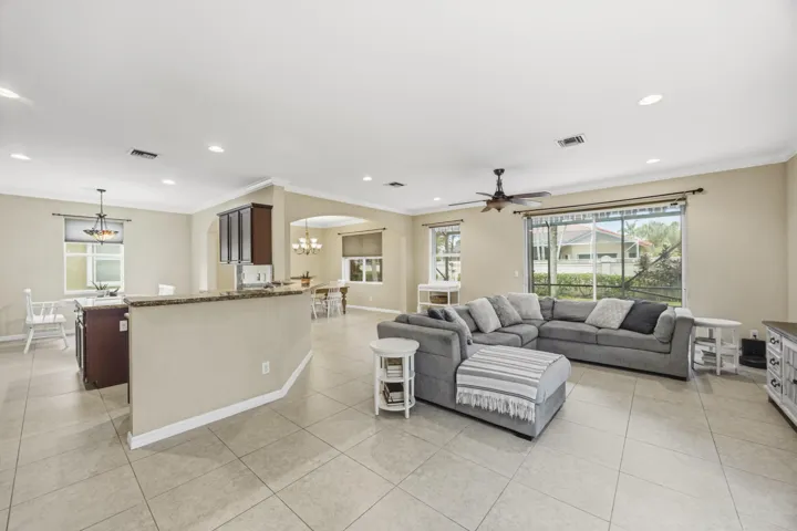 Open-concept living area with tiled flooring, recessed lighting, and a ceiling fan