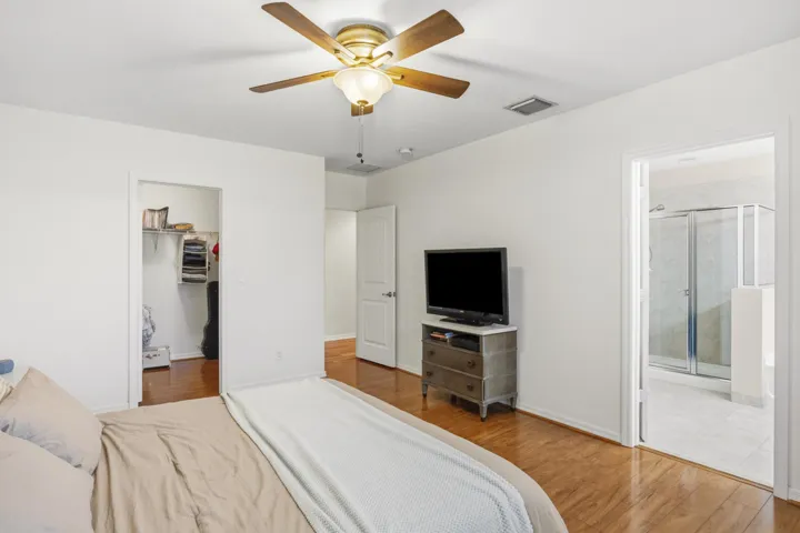 Wood-finish flooring, ceiling fan, and white walls