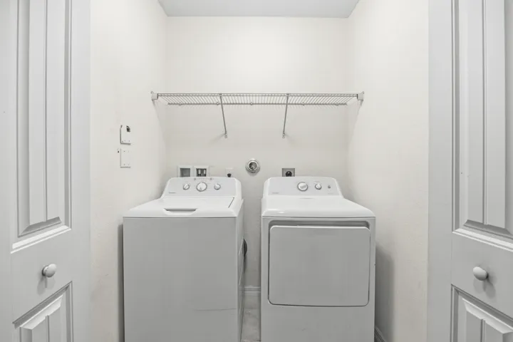 Laundry area with wire shelving, washer, and dryer connections