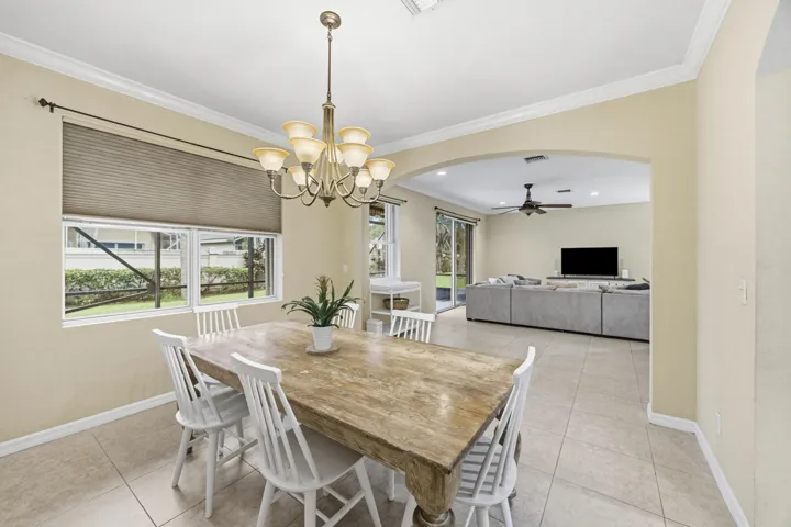 Recessed lighting, crown molding, arched entryway, tile flooring, and a ceiling fan