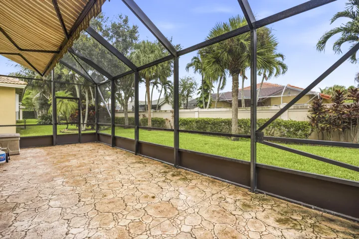 Screened patio with patterned concrete flooring, overhead awning, and open-air enclosure