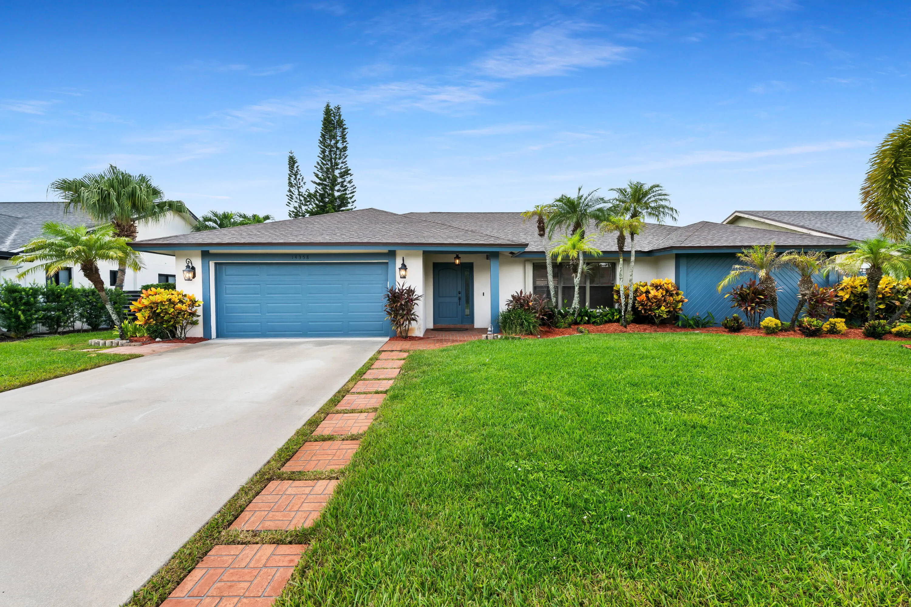 Single-story residence with a light-colored facade, blue garage door, and a gray shingle roof