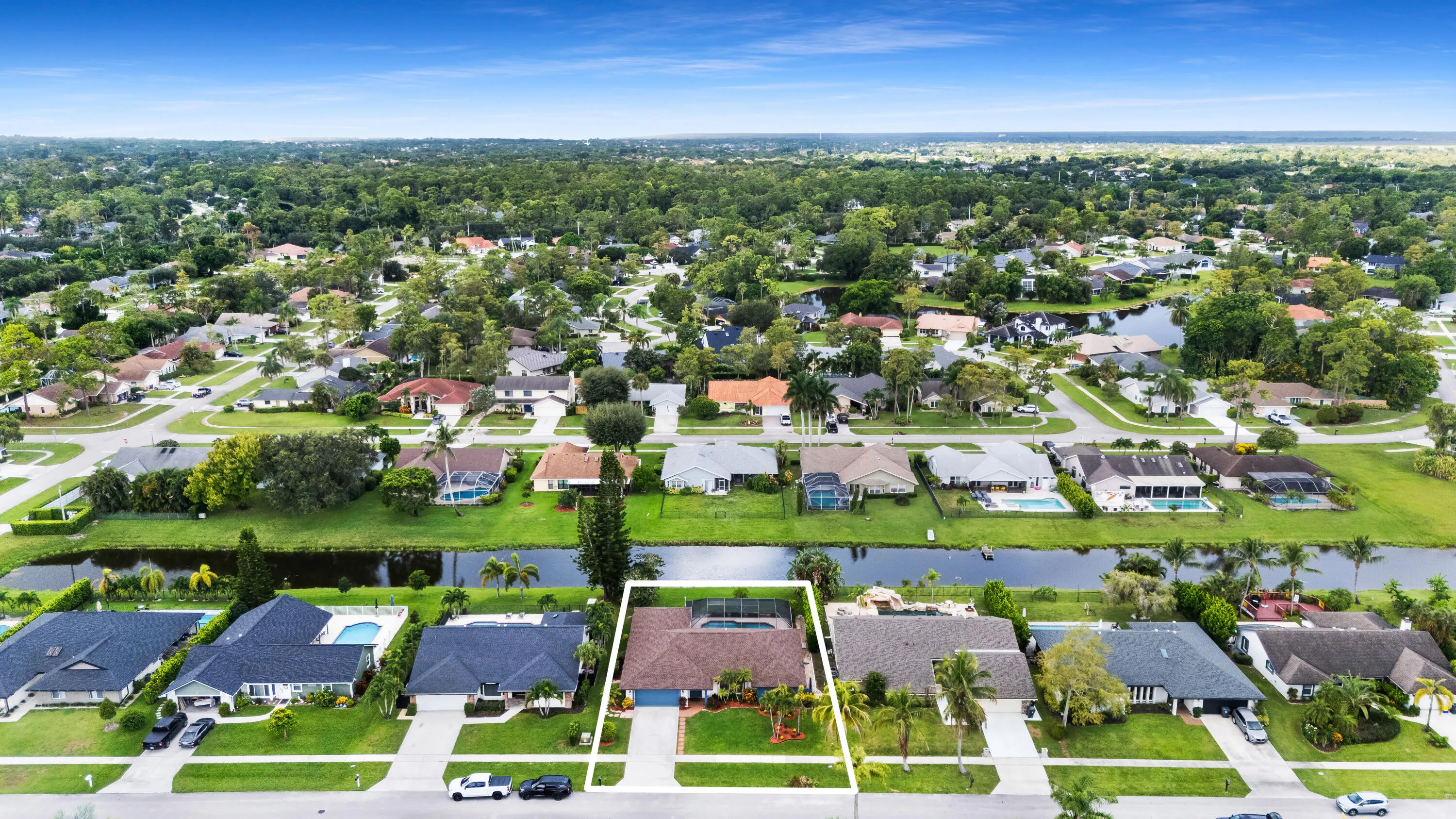 Single-story property with a brown shingle roof, attached garage, paved driveway, and a front lawn with landscaping