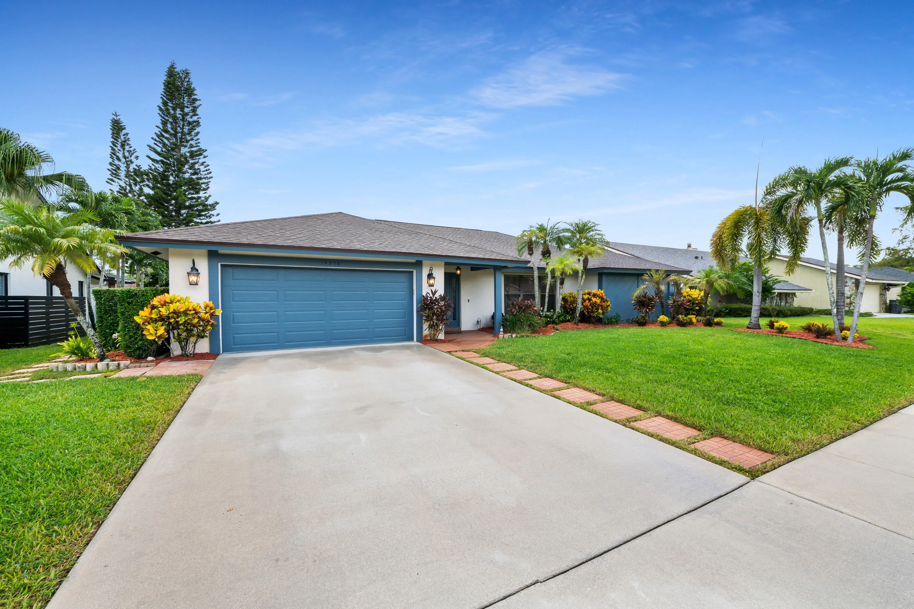 Concrete driveway leading to a two-car garage with a blue door