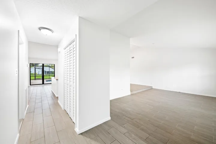 White painted walls with tile flooring, louvered bi-fold door, and a vaulted ceiling