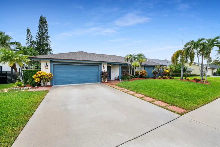 Concrete driveway leading to a two-car garage with a blue door
