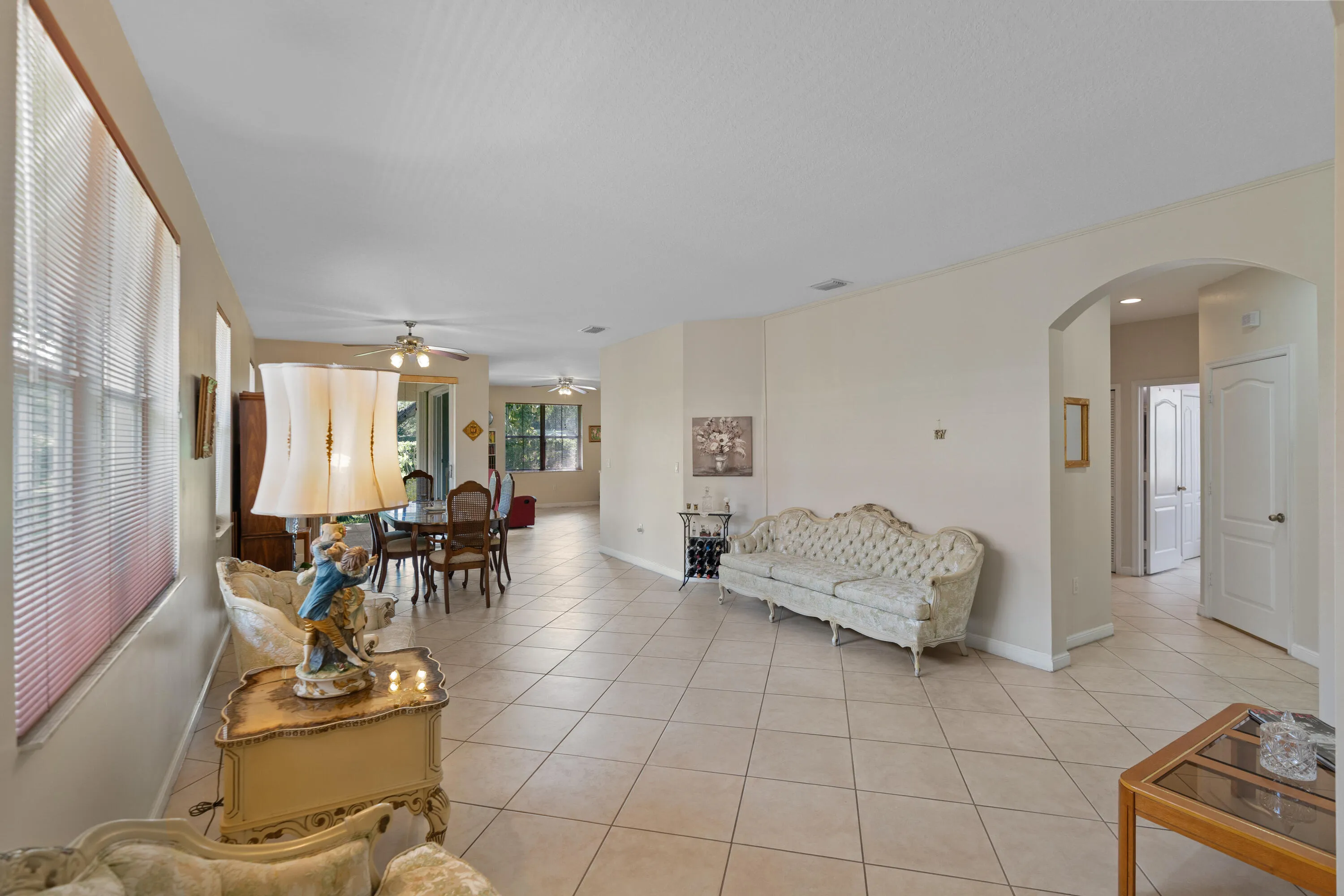 Spacious open-concept living area featuring tile flooring, multiple windows providing natural light.