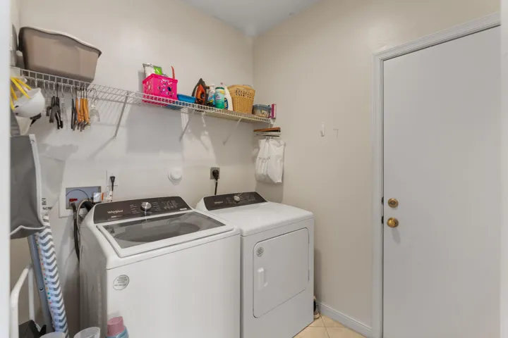 Dedicated laundry area featuring a washer and dryer, complete with overhead wire shelving for storage