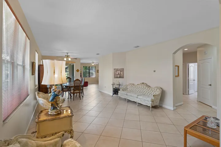 Spacious open-concept living area featuring tile flooring, multiple windows providing natural light.