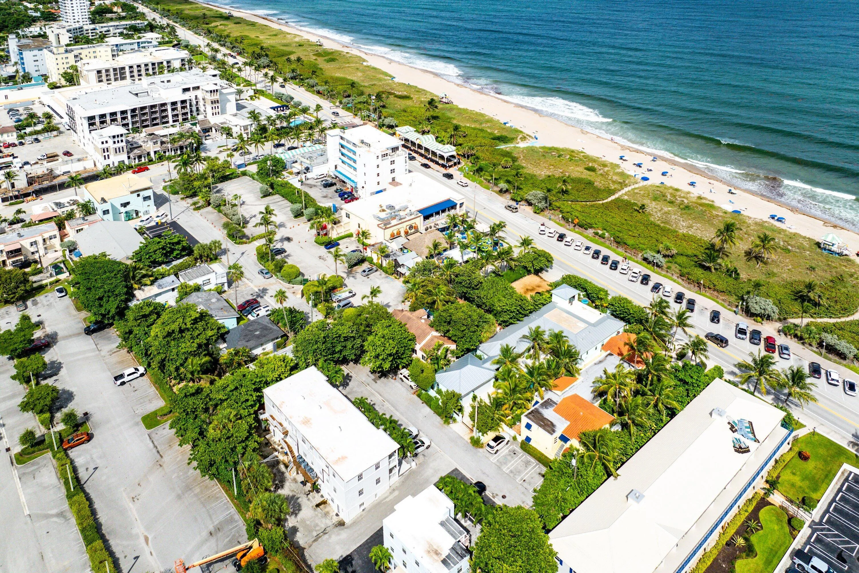 Coastal setting with established residential and commercial structures, a sandy beach, and ocean