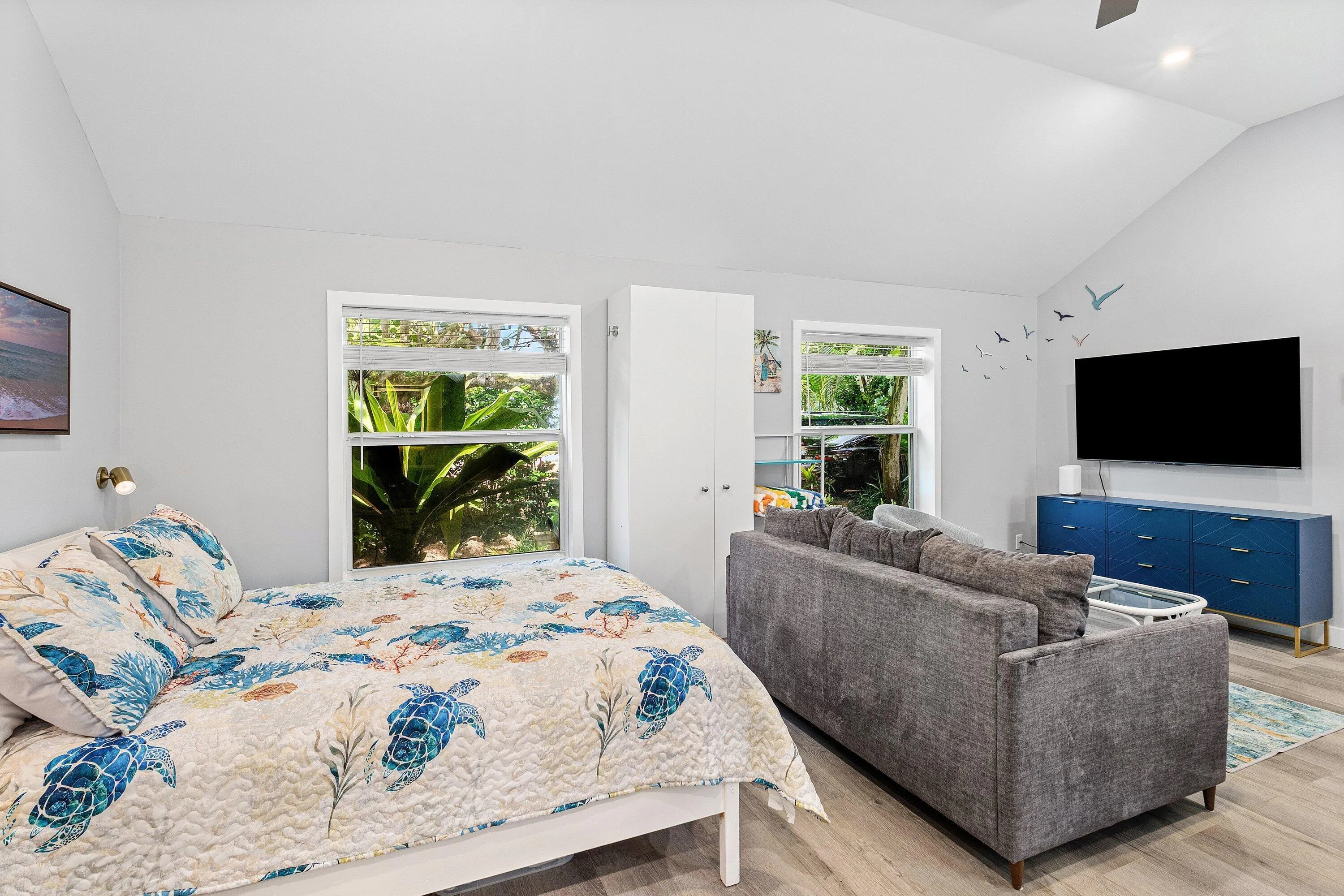 Vaulted ceiling, multiple windows, built-in storage cabinet, recessed lighting, wood-finish flooring