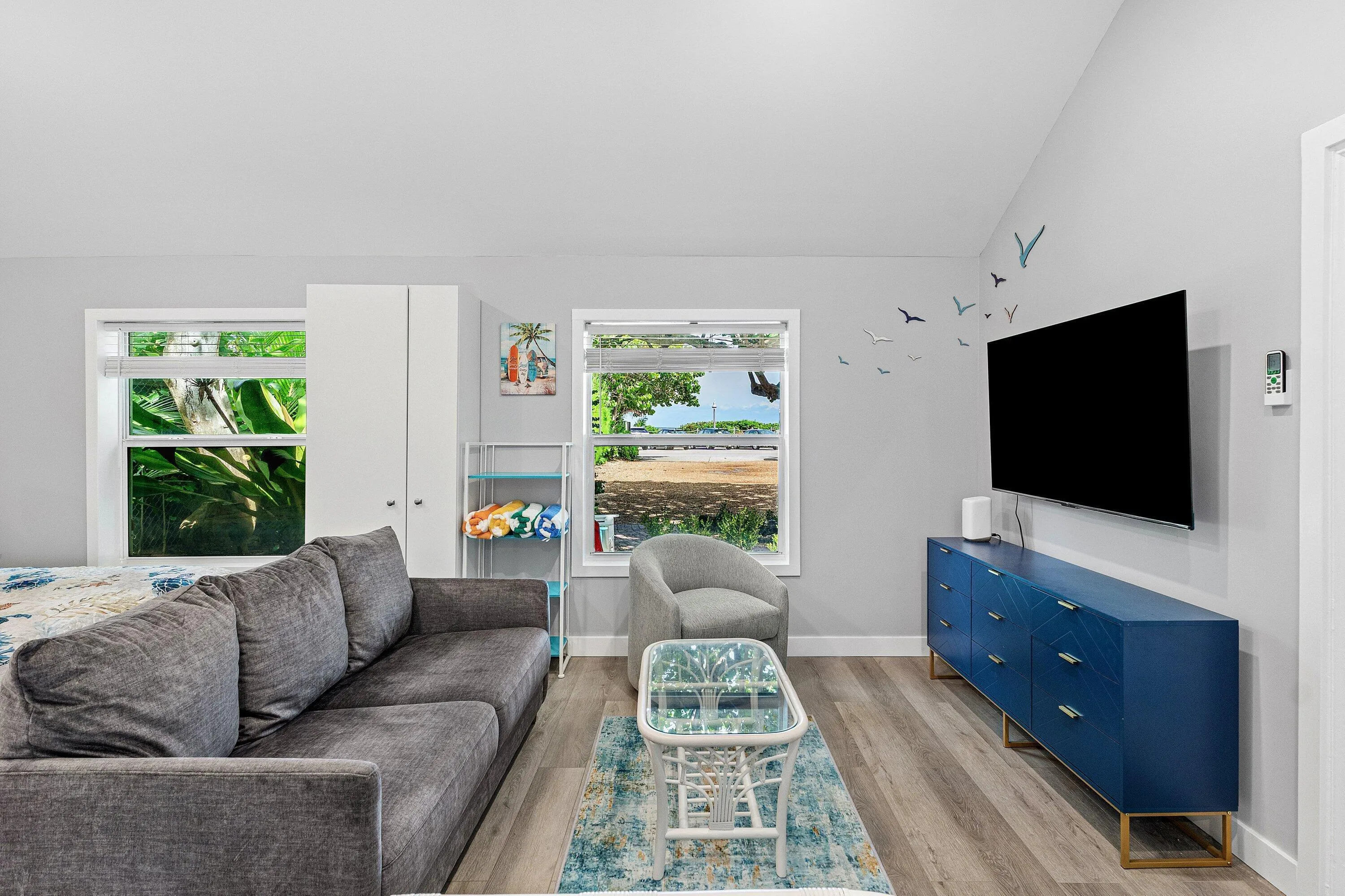 Vaulted ceilings, wood-finish flooring, and multiple windows providing natural light