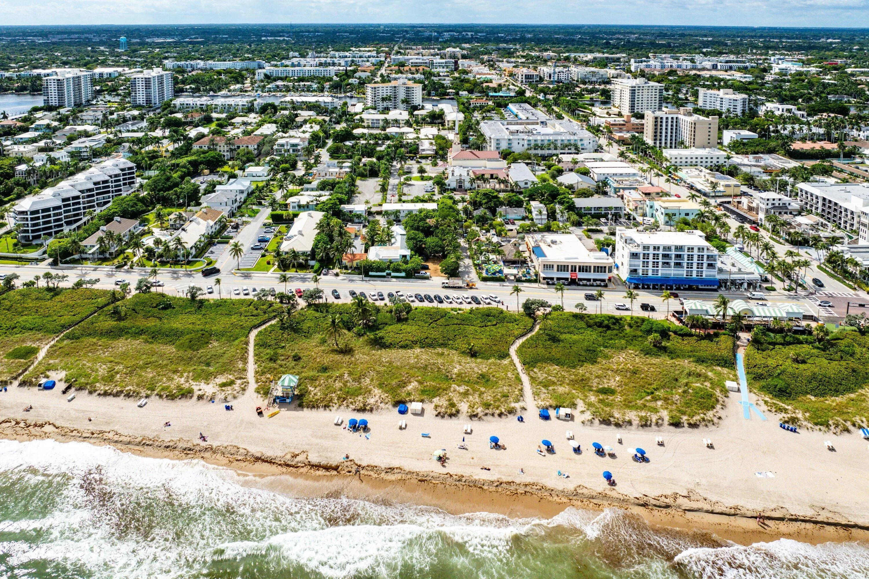 Coastal community featuring sandy beach, ocean access, dense green spaces, and urban infrastructure