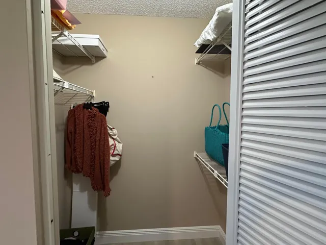 1 of 2 walk in closets in primary bedroom