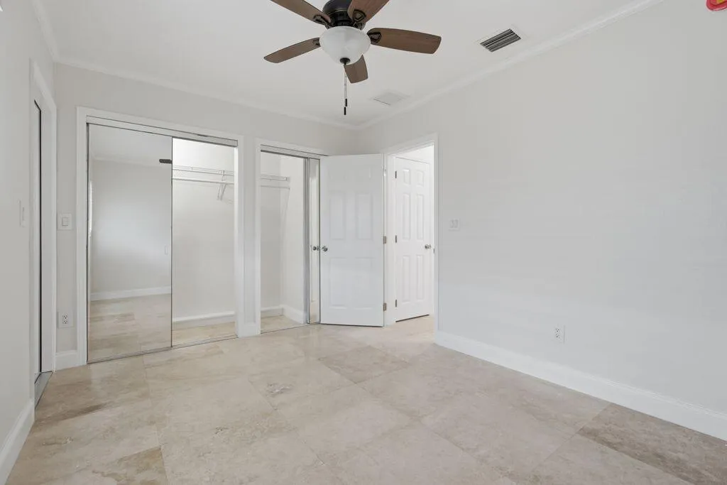 Bedroom closet, ceiling fan, and impact window