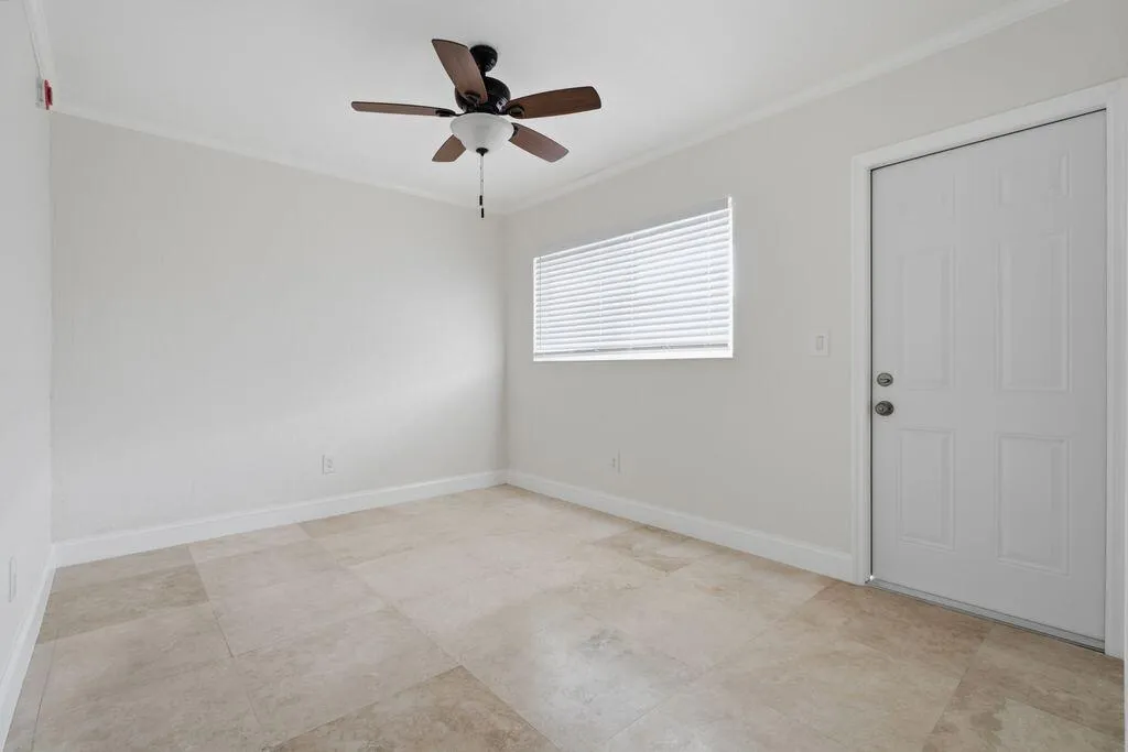 Bedroom has marble floors and rear entry door.